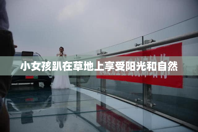 小女孩趴在草地上享受阳光和自然